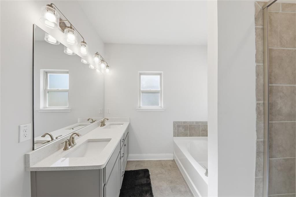 1861 Abbey Road Griffin, GA 30223 - Photo 11 of 26 a bathroom with a sink a tub and a mirror