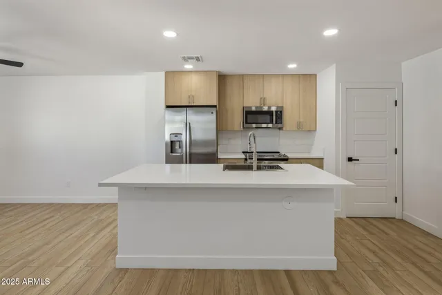 a kitchen with kitchen island a sink appliances and cabinets