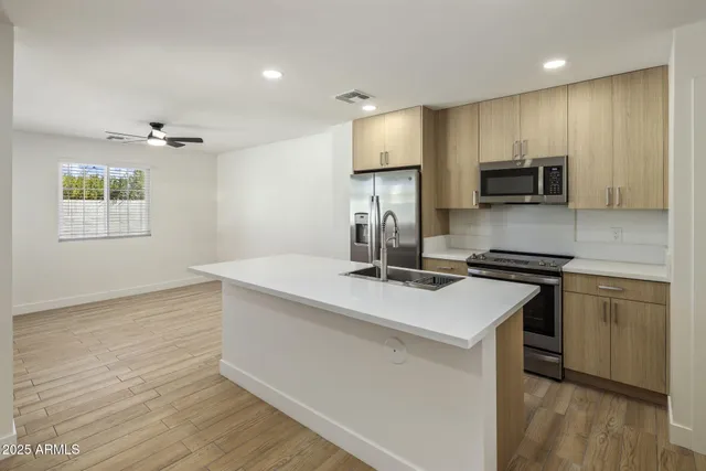 a kitchen with kitchen island a stove a sink and a refrigerator