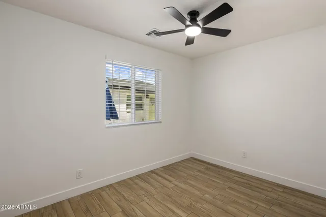 an empty room with a window and a fan