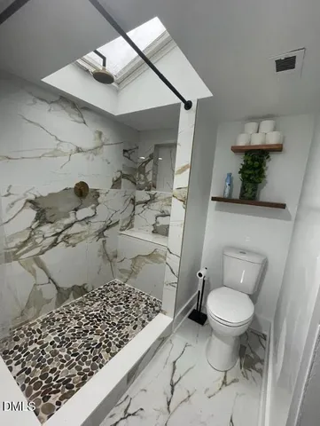 a bathroom with a toilet and a shower