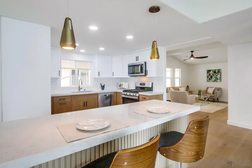 1120 Pepper Drive, Unit 78 El Cajon, CA 92021 - Photo 7 of 16 a kitchen with stainless steel appliances kitchen island granite countertop a kitchen island a stove a sink a refrigerator cabinets and a dining table