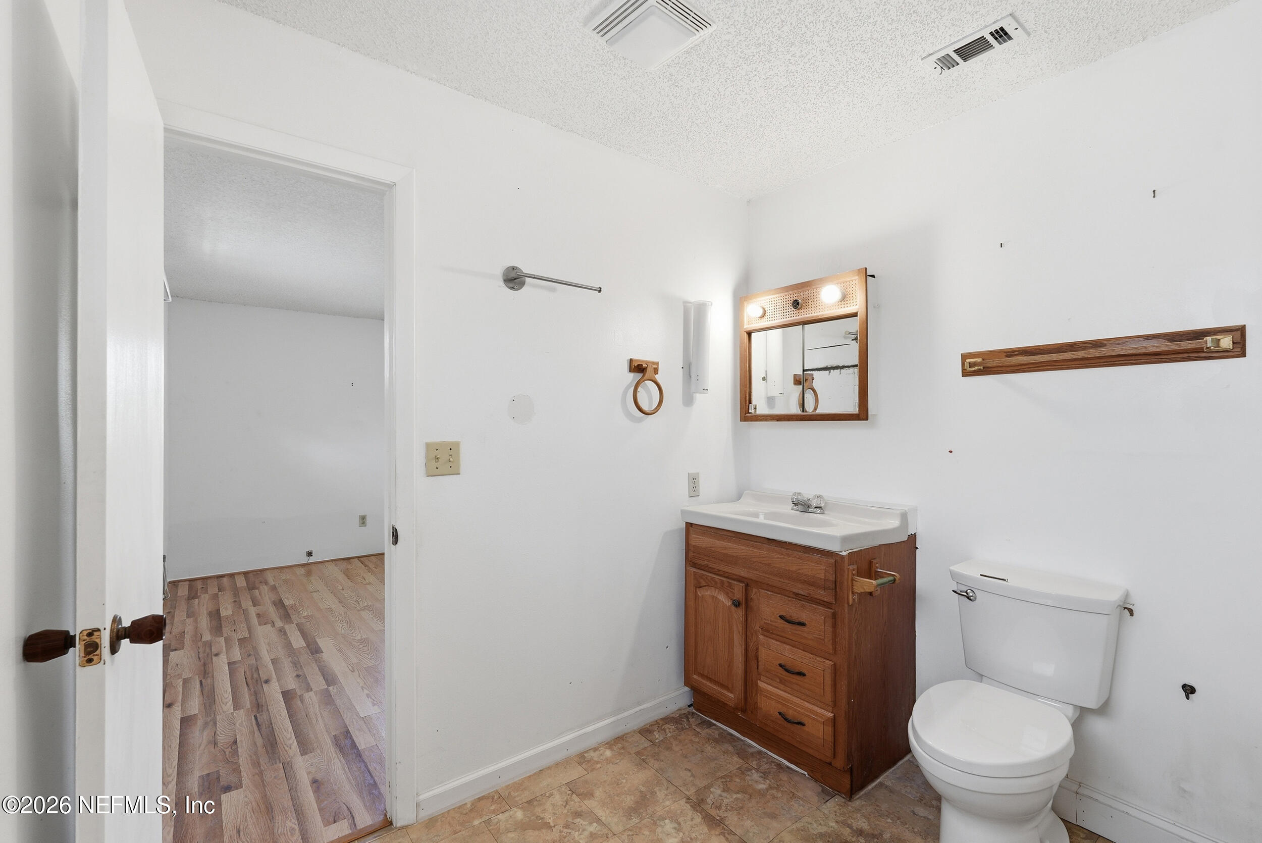 7593 Silver Sands Road Keystone Heights, FL 32656 - Photo 23 of 36 a bathroom with a toilet a sink and mirror