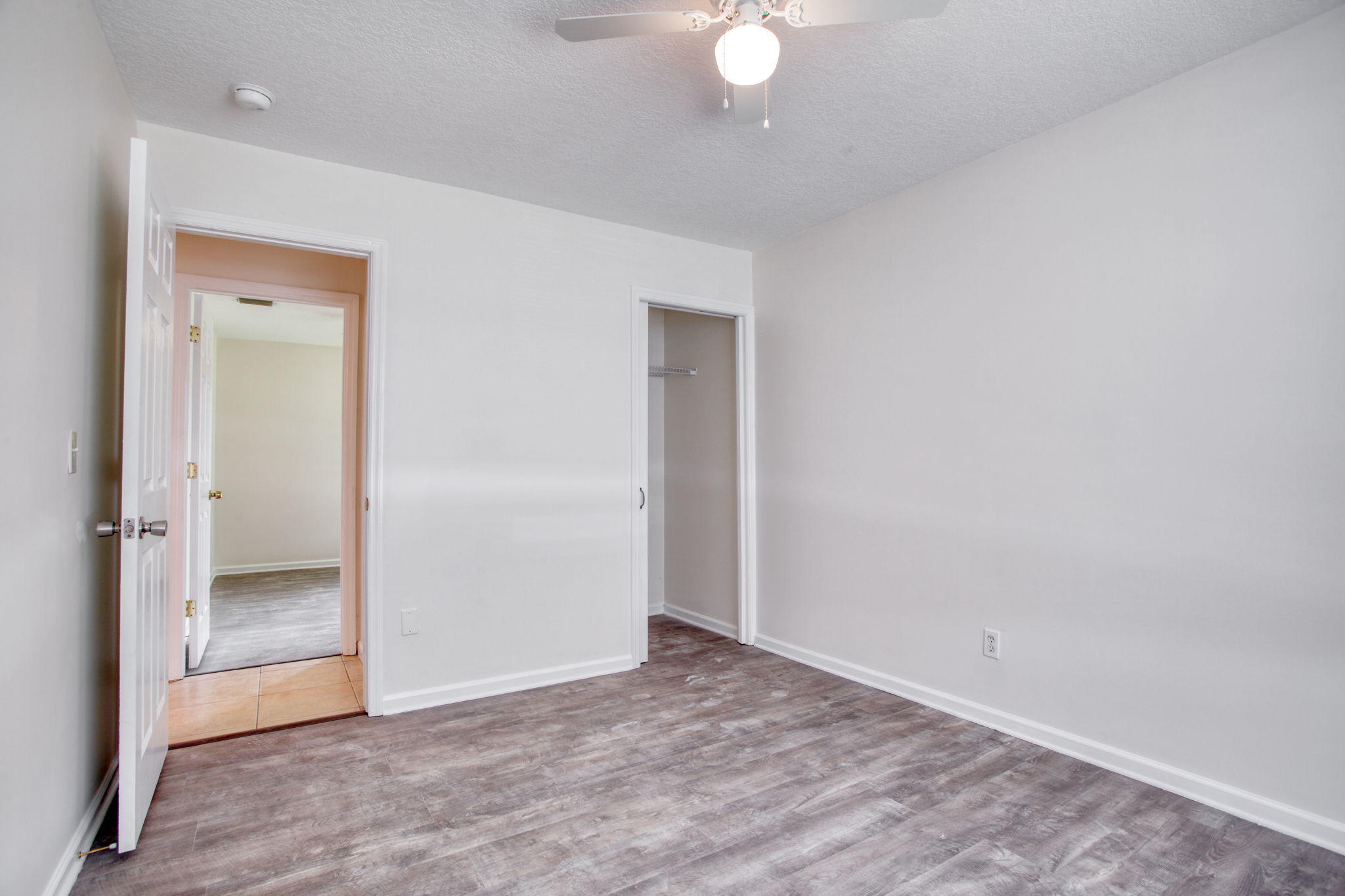 4302 Southwest Jaunt Road Port St. Lucie, FL 34953 - Photo 21 of 32 an empty room with wooden floor and mirror