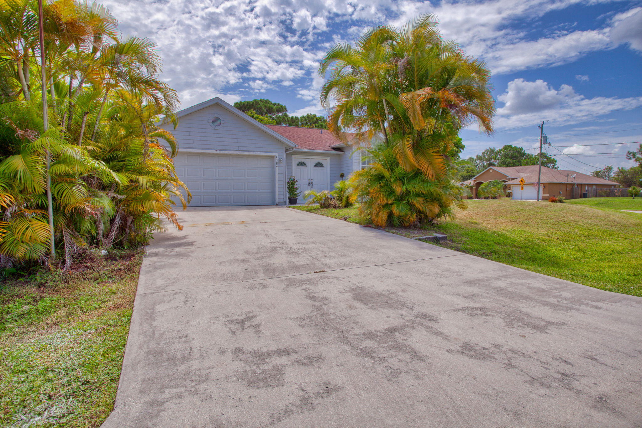 4302 Southwest Jaunt Road Port St. Lucie, FL 34953 - Photo 3 of 32 a house with a yard and a large tree