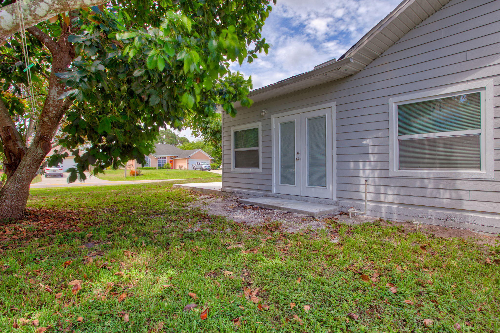 4302 Southwest Jaunt Road Port St. Lucie, FL 34953 - Photo 31 of 32 a view of a house with backyard and a tree