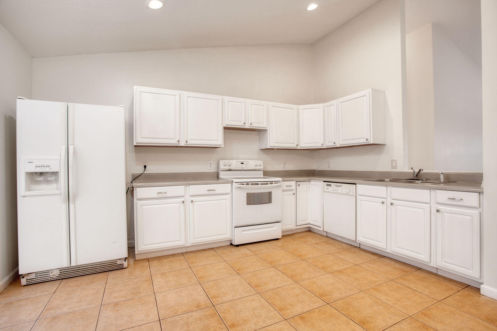4302 Southwest Jaunt Road Port St. Lucie, FL 34953 - Photo 6 of 32 a kitchen with granite countertop white cabinets and white appliances