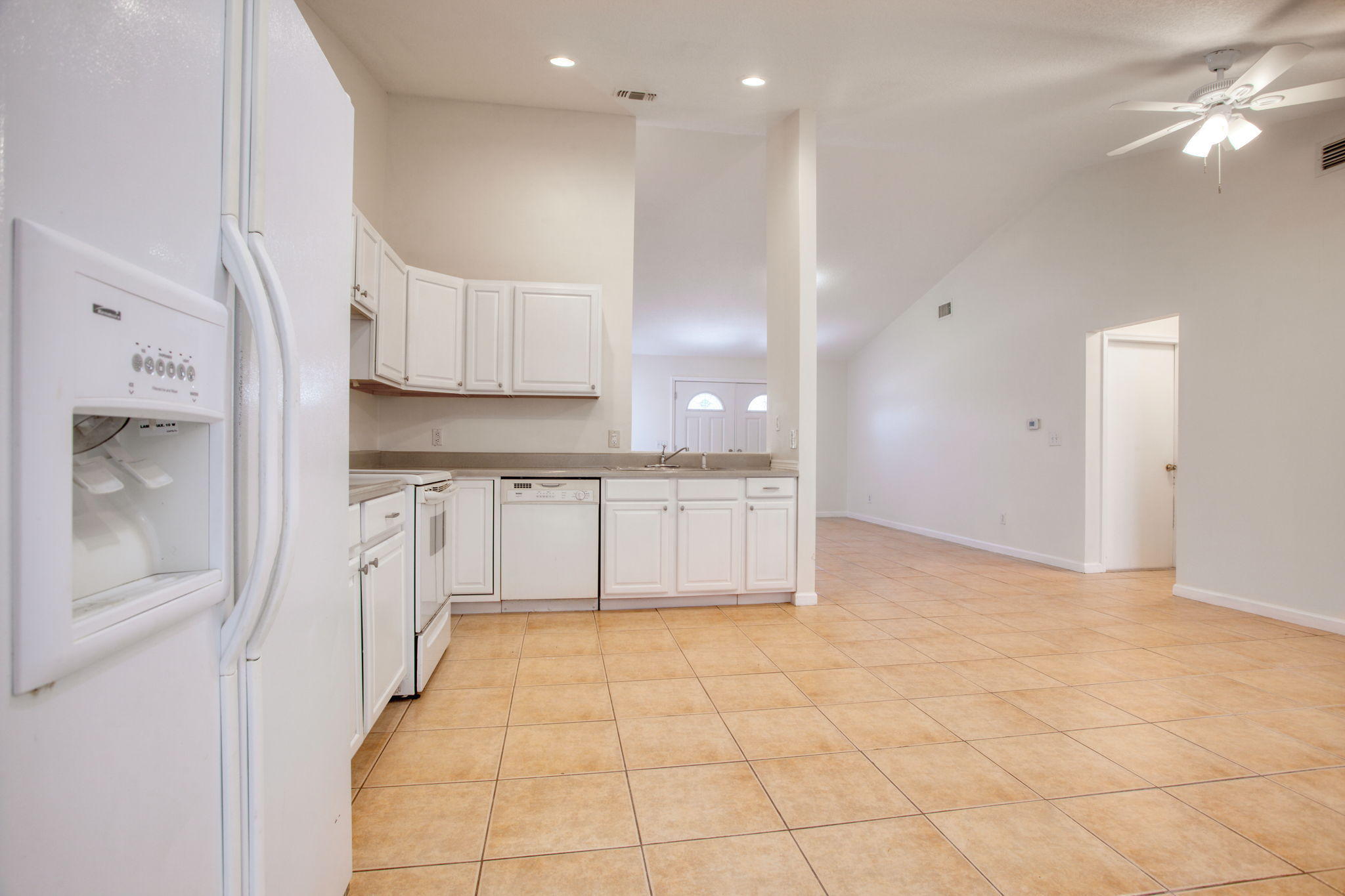 4302 Southwest Jaunt Road Port St. Lucie, FL 34953 - Photo 7 of 32 a large white kitchen with cabinets and a wooden floor