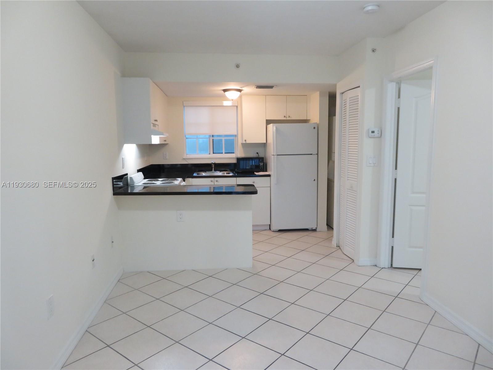 a kitchen with stainless steel appliances granite countertop white cabinets and refrigerator