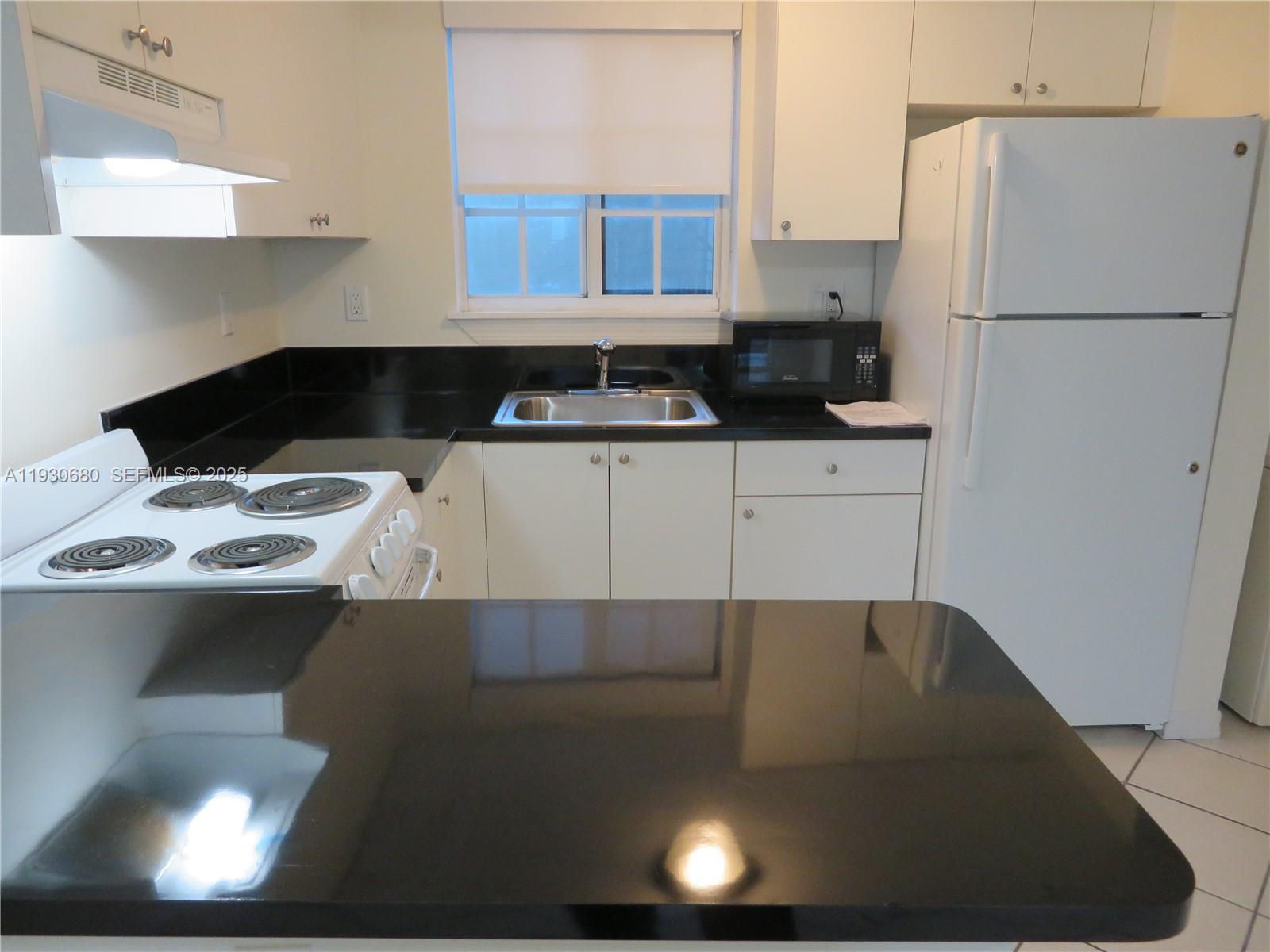 3090 Bird Avenue, Unit 203 Coconut Grove, FL 33133 - Photo 2 of 18 a kitchen with a sink a stove and refrigerator