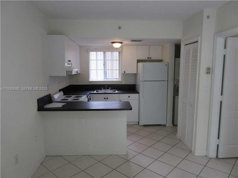 3090 Bird Avenue, Unit 203 Coconut Grove, FL 33133 - Photo 4 of 18 a kitchen with a sink appliances and cabinets
