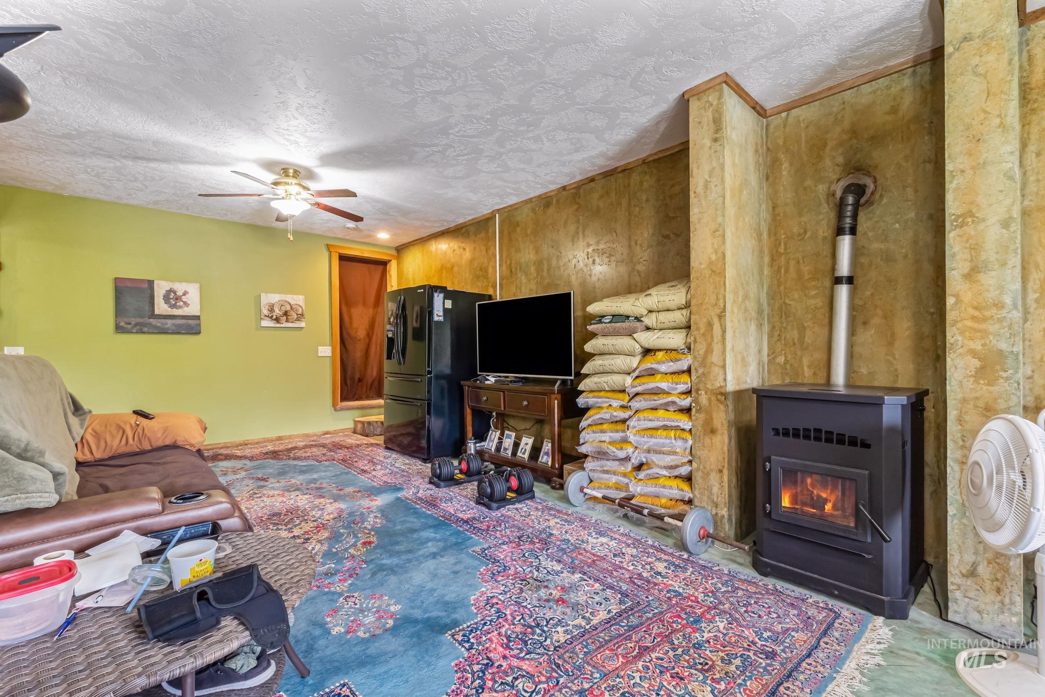 15 Rim Canyon Lane Boise, ID 83716 - Photo 16 of 31 Living room with a textured ceiling, ceiling fan, and a wood stove
