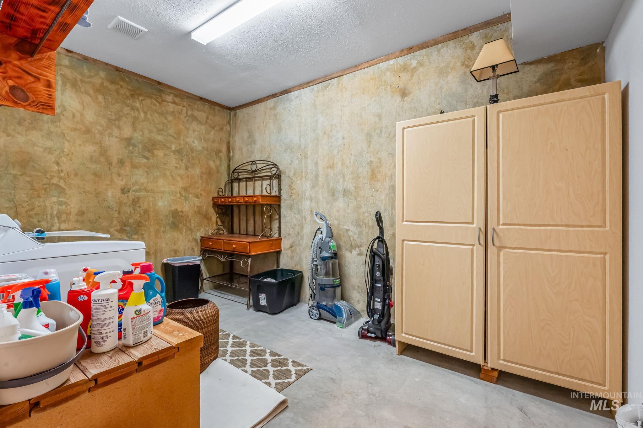 15 Rim Canyon Lane Boise, ID 83716 - Photo 20 of 31 Miscellaneous room featuring concrete flooring, a textured ceiling, and washer and dryer