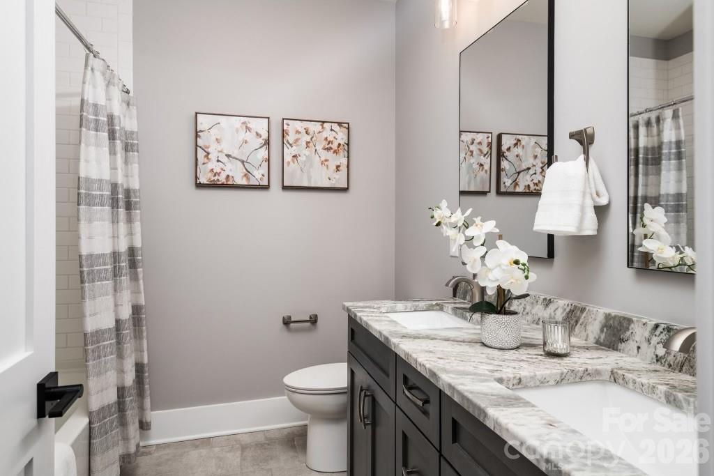 116 Silver Falls Road Troutman, NC 28166 - Photo 40 of 46 a bathroom with a granite countertop sink a toilet and a mirror