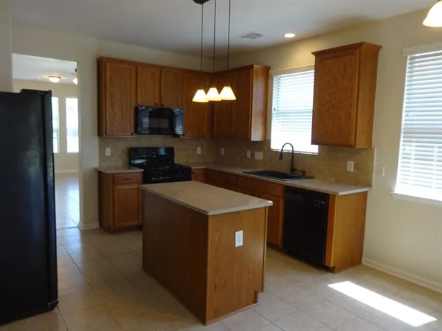 a kitchen with a sink stove and refrigerator
