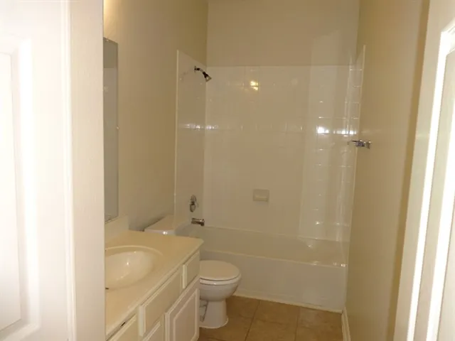 a bathroom with a granite countertop sink a toilet and shower