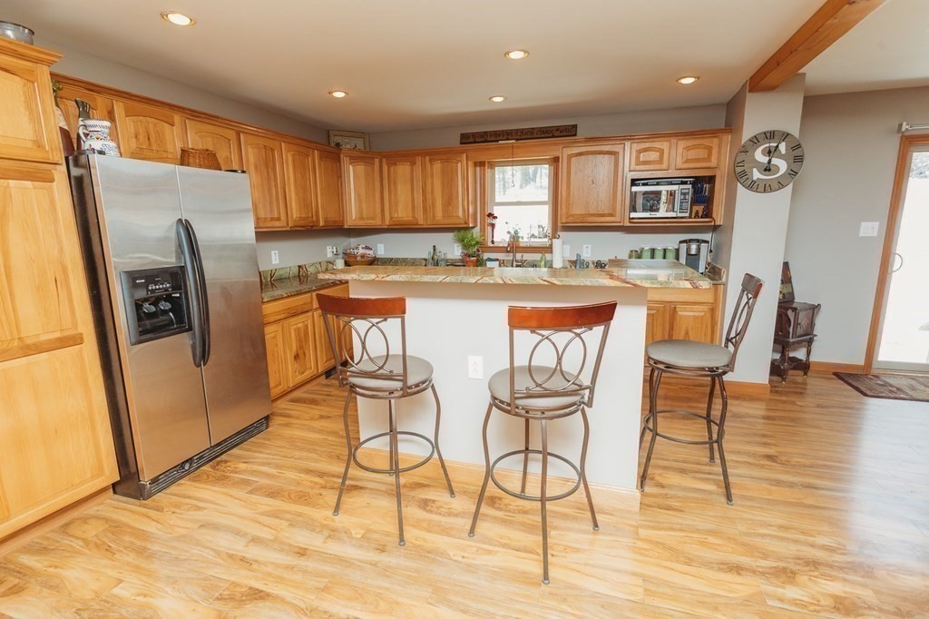 123 Davis Mine Road Rowe, MA 01367 - Photo 16 of 41 a kitchen with stainless steel appliances granite countertop a refrigerator a stove top oven and a dining table with wooden floor
