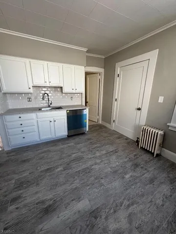 a view of a kitchen with granite countertop cabinets and wooden floor