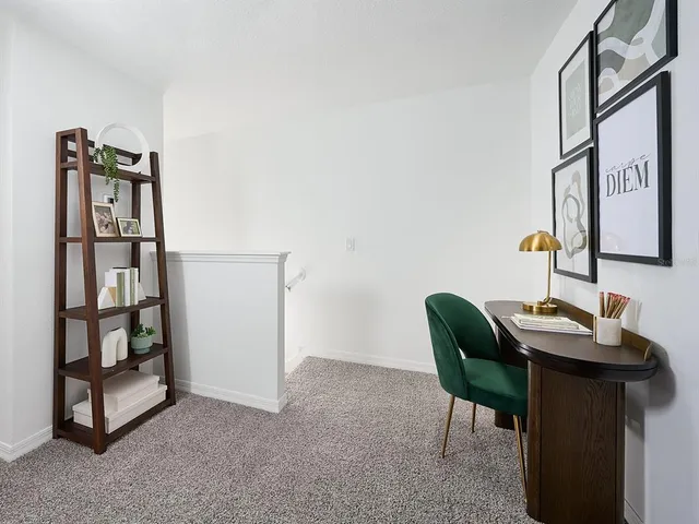 a view of a workspace with furniture and a window