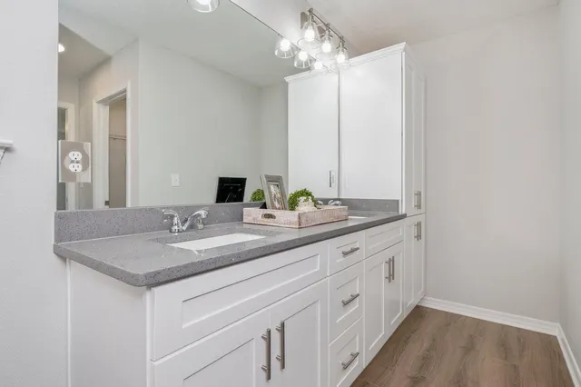 a bathroom with a granite countertop sink and a mirror