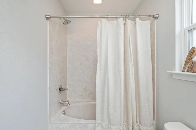 a bathroom with a shower curtain and a sink