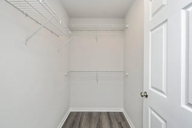 a view of walk in closet with empty racks