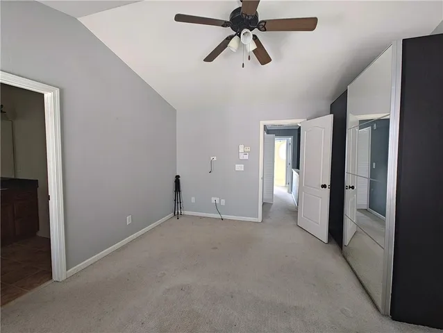 an empty room with closet and a chandelier fan