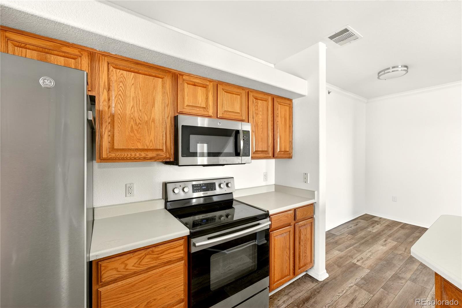 18929 East Warren Circle, Unit C205 Aurora, CO 80013 - Photo 11 of 46 a kitchen with a stove microwave and sink