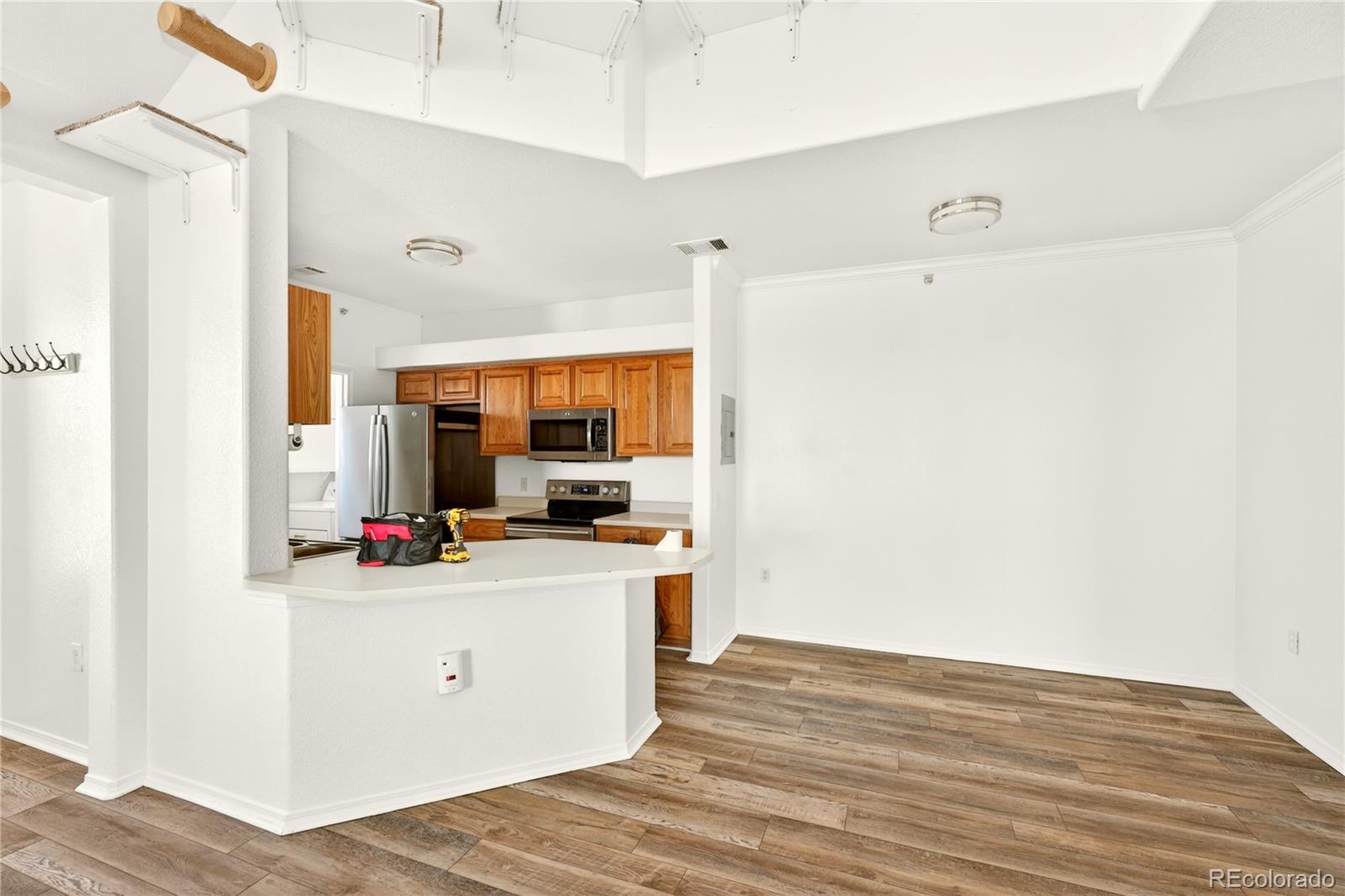 18929 East Warren Circle, Unit C205 Aurora, CO 80013 - Photo 21 of 46 a kitchen with a stove a refrigerator and a microwave