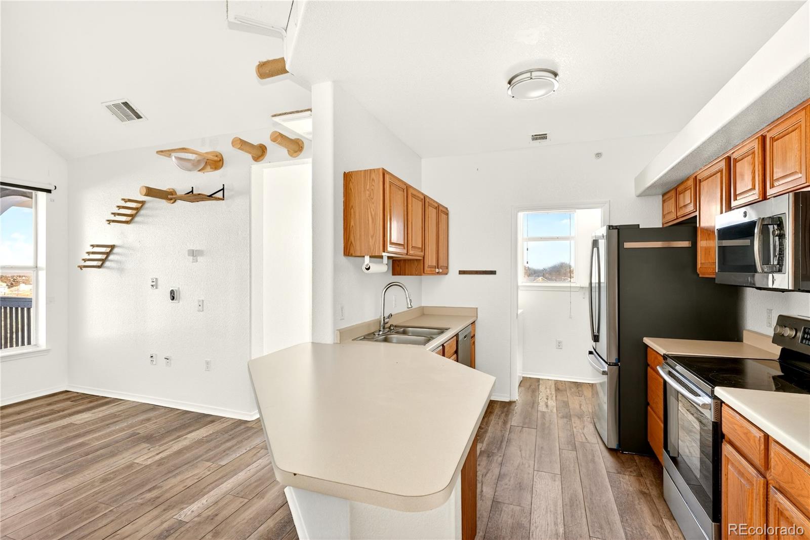 18929 East Warren Circle, Unit C205 Aurora, CO 80013 - Photo 10 of 46 a kitchen with granite countertop a sink stove and refrigerator