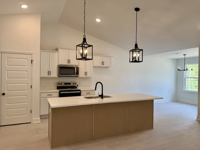 a kitchen with stainless steel appliances a sink a stove a refrigerator and cabinets