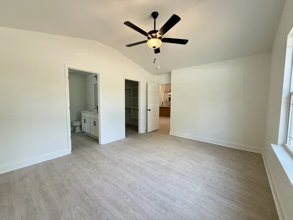 an empty room to closet and a ceiling fan