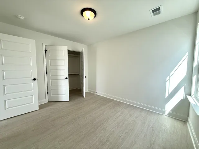 an empty room with closet and a window