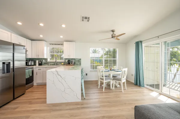 a bedroom with a white bed and a painting on the wall