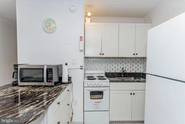 a white stove top oven sitting inside of a kitchen