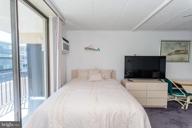 a bedroom with a bed wooden floor and window