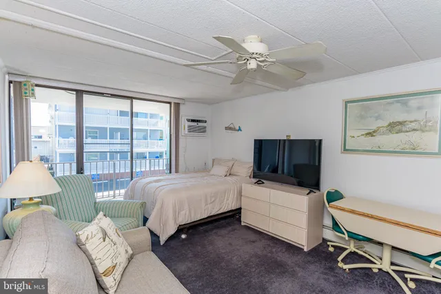 a bedroom with a bed a large window and furniture