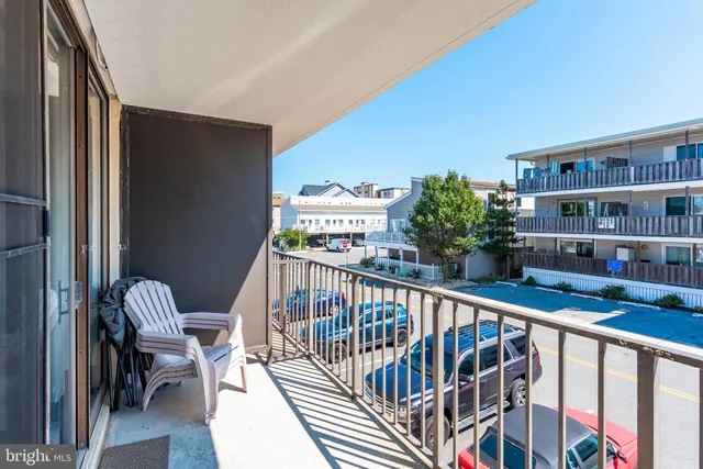 a view of a balcony with chairs and a potted plant