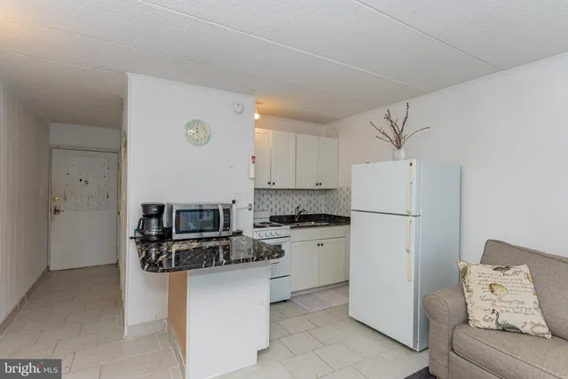 a kitchen with stainless steel appliances white cabinets and a refrigerator