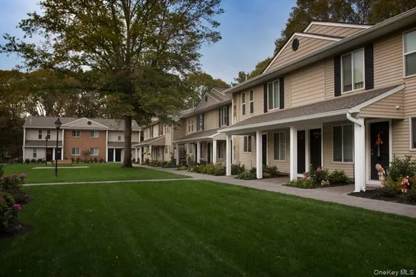 front view of a brick house with a yard