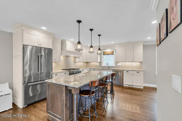a kitchen with appliances a counter space and wooden floor