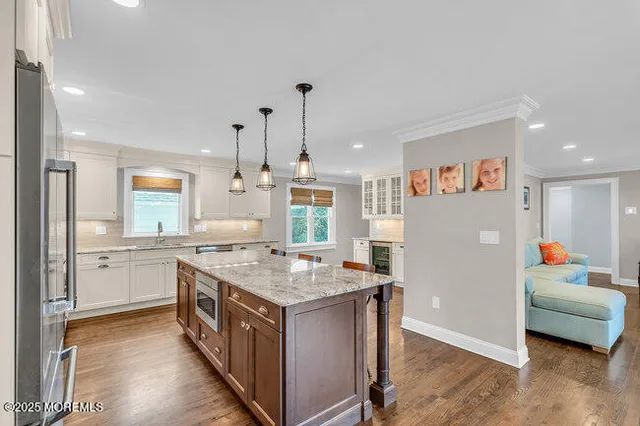 a kitchen that has a lot of cabinets a sink and a wooden floor in it
