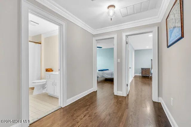 a living room with a couch and a dining table with wooden floor