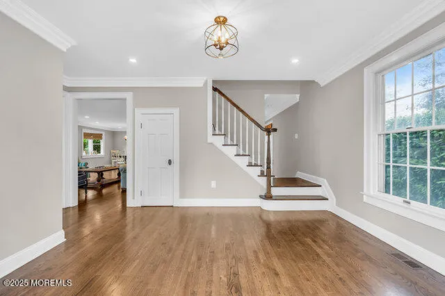 a view of entryway and hall with wooden floor