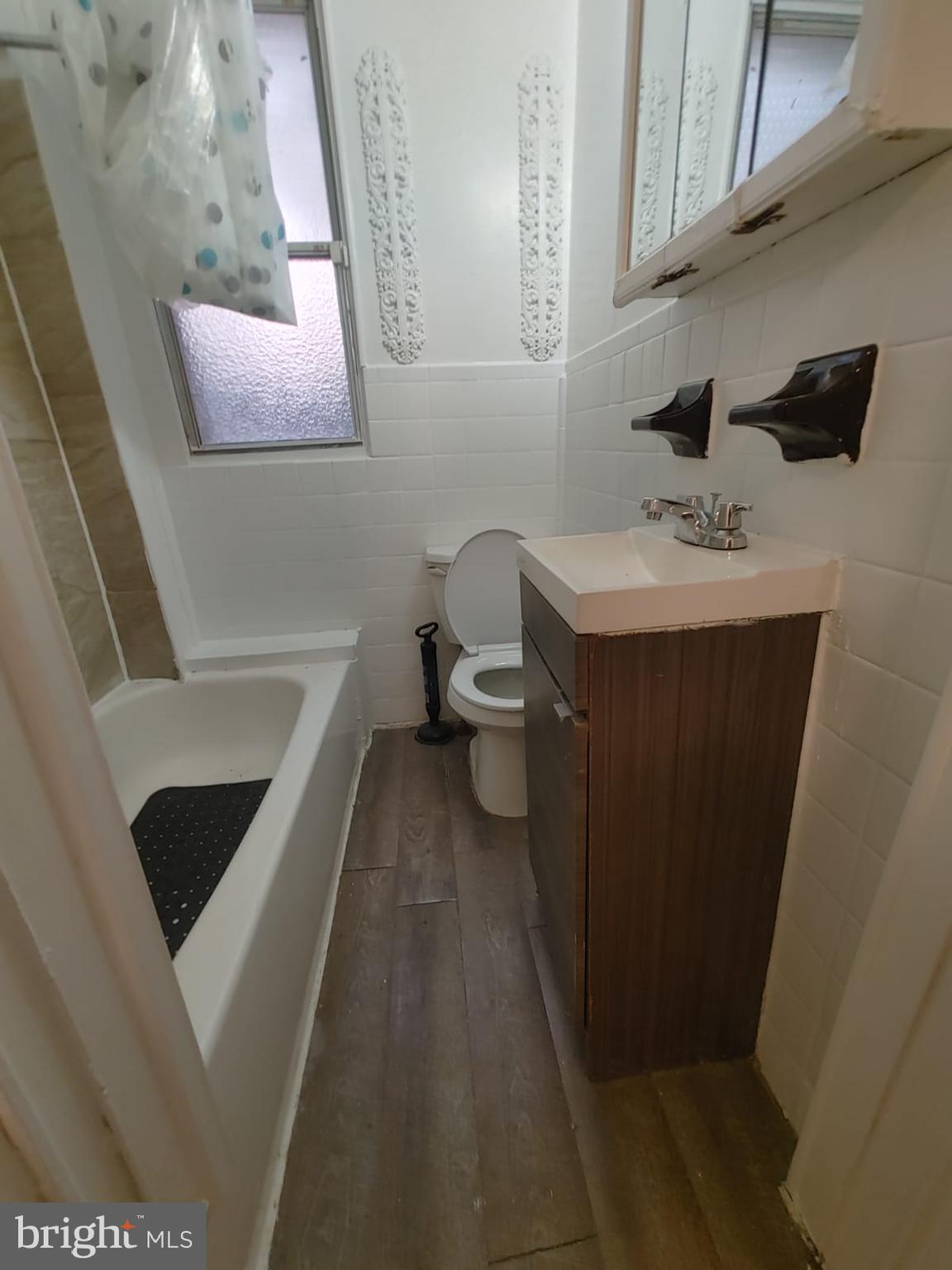 208-210 North Avondale Street Philadelphia, PA 19139 - Photo 7 of 15 a bathroom with a sink a toilet and mirror