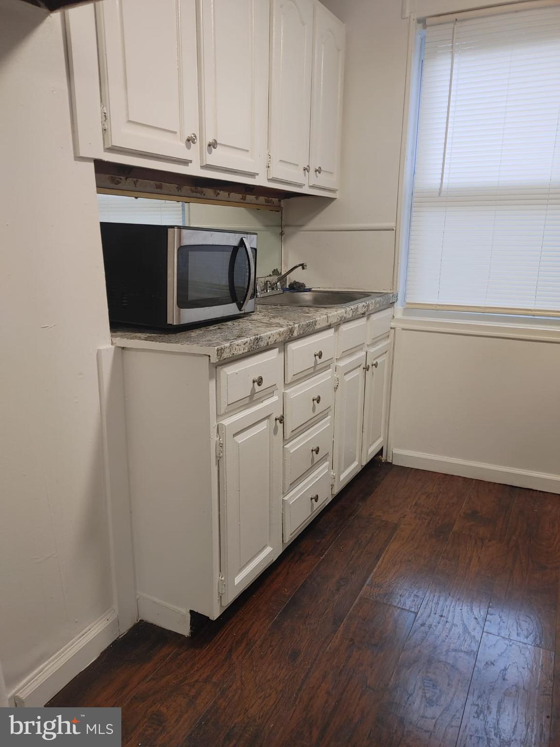 208-210 North Avondale Street Philadelphia, PA 19139 - Photo 9 of 15 a kitchen with sink cabinets and wooden floor
