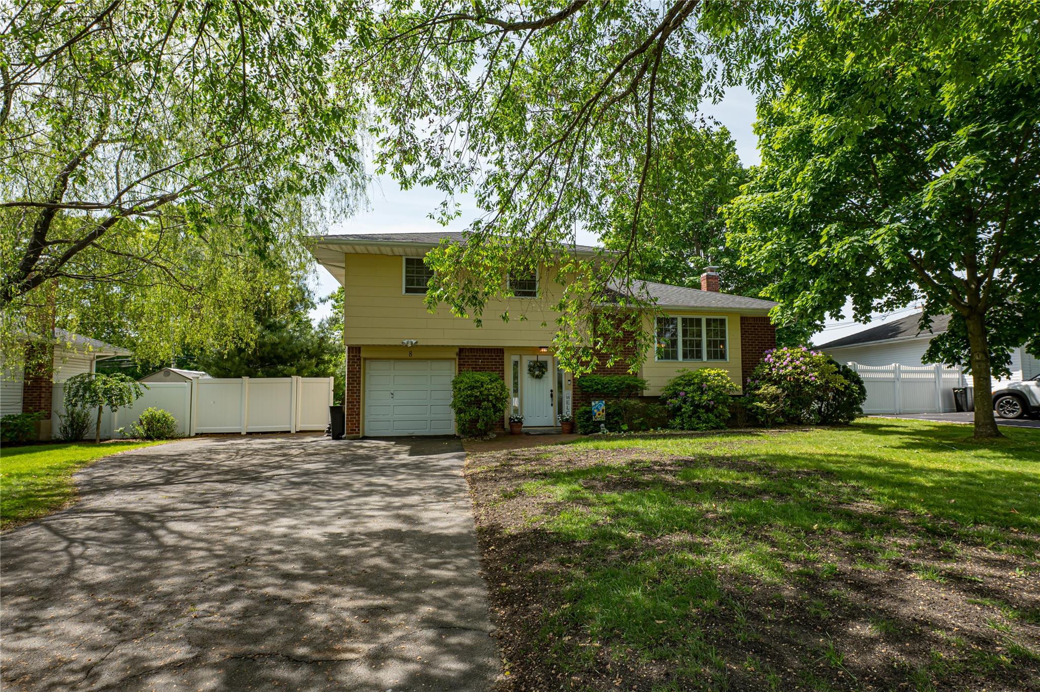8 Baylor Drive Smithtown, NY 11787 - Photo 1 of 1 a front view of a house with a garden and trees