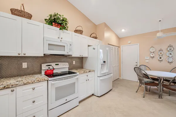 a kitchen with granite countertop a sink and a stove top oven