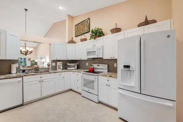 a kitchen with kitchen island a appliances dining table and chairs