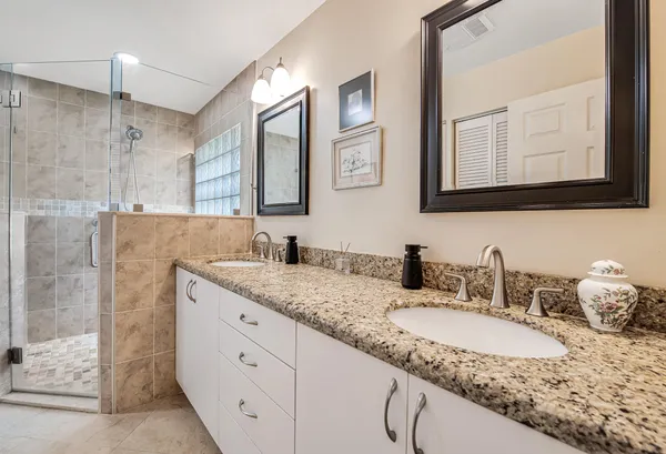 a bathroom with a granite countertop toilet sink and mirror
